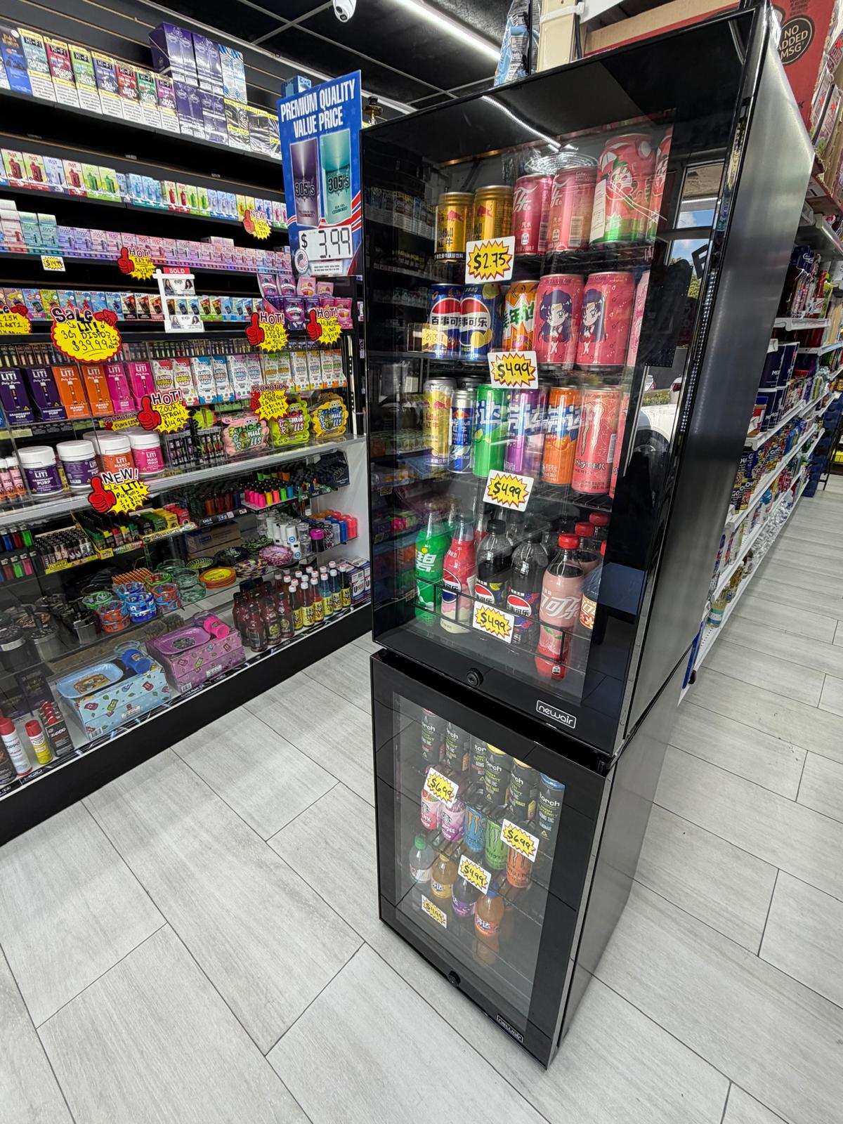 Cold drinks cooler with imported sodas, energy drinks, and bottled beverages at One Stop Market N Smoke Shop in Hialeah, FL.